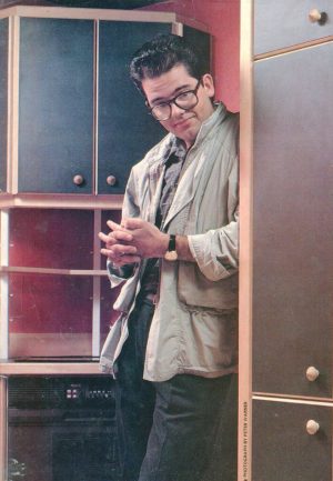 Young Mark Lewis leaning against cupboards